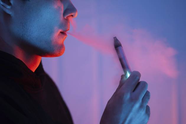 Nahaufnahme eines Mannes, der eine elektronische Zigarette raucht. farbiges Licht Close-up of a man smoking an electronic cigarette. colored light Copyright: imageBROKER PavelxMarys ibxiqx17866551.jpg ,model released, Symbolfoto ,property released