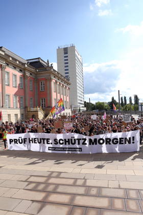 Demonstranten laufen mit Banner Prüf heute. Schütz morgen! um den Landtag während einer Demonstration für die Überprüfung rechtsextremer Parteien durch das Bundesverfassungsgericht, Alter Markt, Potsdam, 12. September 2026. Prüf-Demo in Potsdam