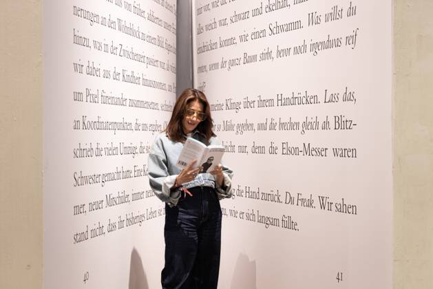 78. Frankfurter Buchmesse Eine Besucherin der Frankfurter Buchmesse ließt ein Buch in einem riesigen Buch-Modell. Die 78. Frankfurter Buchmesse findet vom 7. - 11. Oktober 2026 statt. Frankfurt am Main Messegelände Hessen Deutschland