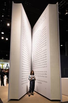 78. Frankfurter Buchmesse Eine Besucherin der Frankfurter Buchmesse ließt ein Buch in einem riesigen Buch-Modell. Die 78. Frankfurter Buchmesse findet vom 7. - 11. Oktober 2026 statt. Frankfurt am Main Messegelände Hessen Deutschland