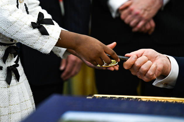 Trump Makes Oval Office Announcement WASHINGTON, DC - OCT. 7: US President Donald Trump hands a challenge coin and a pen to a child during an announcement on Trump Accounts in the Oval Office on Wednesday, Oct. 7, 2026 at the White House in Washington, D.C. (Photo by Annabelle Gordon Pool For The Washington Post) Washington DC United States Copyright: xPool ABACAx