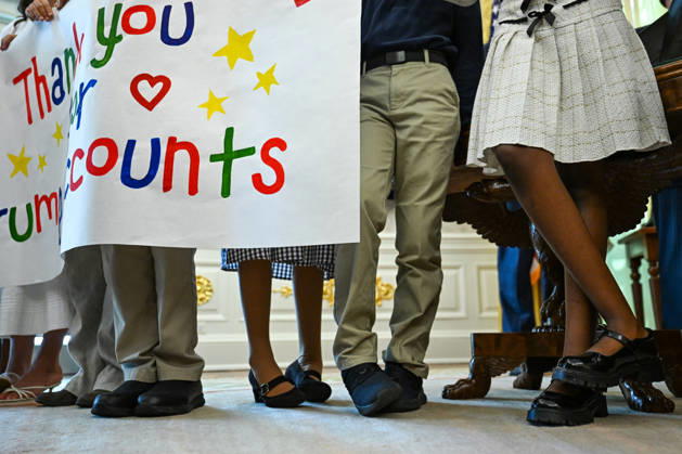 Trump Makes Oval Office Announcement WASHINGTON, DC - OCT. 7: Kids holding a sign shift their feet as US President Donald Trump speaks during an announcement on Trump Accounts in the Oval Office on Wednesday, Oct. 7, 2026 at the White House in Washington, D.C. (Photo by Annabelle Gordon Pool For The Washington Post) Washington DC United States Copyright: xPool ABACAx