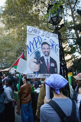 October 7, 2026, New York, New York, USA: A demonstrator wearing a keffiyeh holds a poster during a pro-Palestinian protest at City Hall Park in New York City, New York. New York USA - ZUMAs237 20261007_aap_s237_020 Copyright: xMarkxJ.xSullivanx