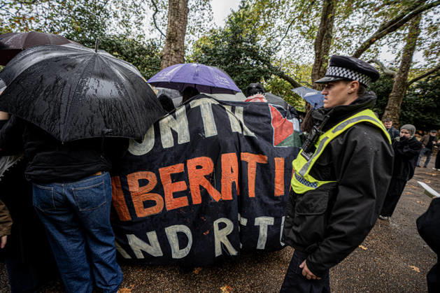 Pro-Israeil counter protestors challenge pro-Palestine demonstrators in London, UK - 7 OCT 2026. A police man seen standing as pro-Palestine activists from London universities shield themselves behind a protective wall of umbrellas during their march. Pro-Palestine activists from Central London Universities chose the 3rd anniversary of the October 7th attack by Hamas to protest against Israel’s war on Gaza. They clashed en route with pro-Israeli counter protestors. The demonstration was arranged by an inter-uni coalition that includes King’s College and LSE. London United Kingdom Copyright: xLabxMox xSOPAxImagesx LabMO_Oct_7th_Uni_Protest_SOPA_2