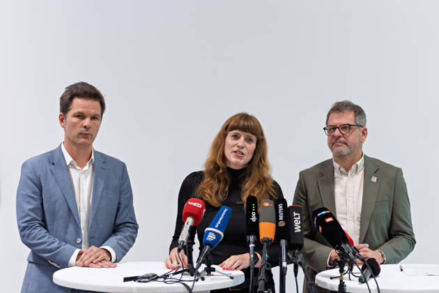 Berlin, 08.10.2026: Kerstin Wolter-Ehling (Die Linke, M.) äußert sich neben Steffen Krach (SPD, l.) und Werner Graf (Bündnis 90 Die Grünen, r.) nach Abschluss der Vorgespräche ihrer Parteien im Foyer des Hauses der Statistik vor Journalisten. Pressestatement von Linke, Grünen und SPD in Berlin