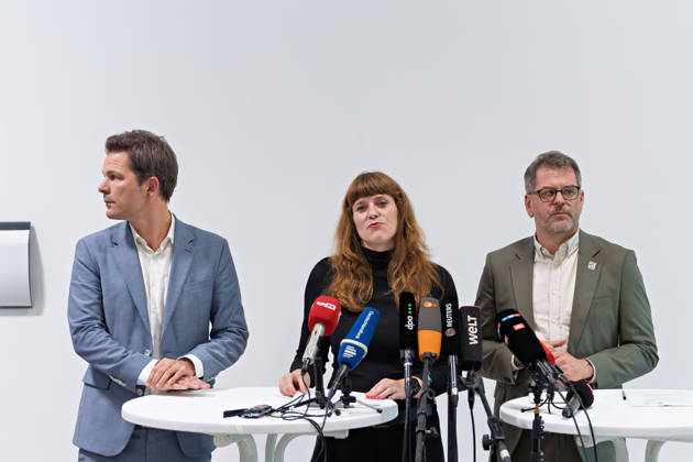 Berlin, 08.10.2026: Kerstin Wolter-Ehling (Die Linke, M.) spricht neben Steffen Krach (SPD, l.) und Werner Graf (Bündnis 90 Die Grünen, r.) beim gemeinsamen Pressestatement nach Abschluss der Vorgespräche ihrer Parteien im Foyer des Hauses der Statistik vor den Mikrofonen. Pressestatement von Linke, Grünen und SPD in Berlin