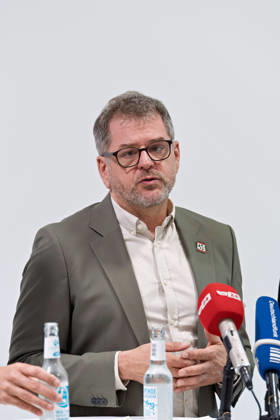 Berlin, 08.10.2026: Werner Graf (Bündnis 90 Die Grünen) spricht beim gemeinsamen Pressestatement von Die Linke Berlin, Bündnis 90 Die Grünen Berlin und SPD Berlin nach Abschluss der Vorgespräche im Foyer des Hauses der Statistik in die Mikrofone der Medien. Pressestatement von Linke, Grünen und SPD in Berlin