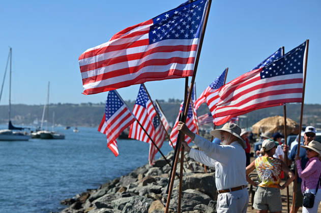 USS Abraham Lincoln returns to home port of San Diego after near-record deployment SAN DIEGO, UNITED STATES - OCTOBER 08: A man places US flags with other onlookers as the USS Abraham Lincoln Nimitz-class aircraft carrier approaches its homeport at Naval Air Station North Island on return from its historic 10-month deployment on October 8, 2026 as seen from the Port of San Diego in San Diego, California, United States. The USS Abraham Lincoln (CVN 72) set a U.S. Navy record spending over 260 days consecutively at sea without a port call while playing a key role in Operation Epic Fury and regional maritime security operations in the Middle East. Carlos A. Moreno Anadolu San Diego United States. Editorial use only. Please get in touch for a Copyright: x2026xAnadoluxCarlosxA.xMorenox