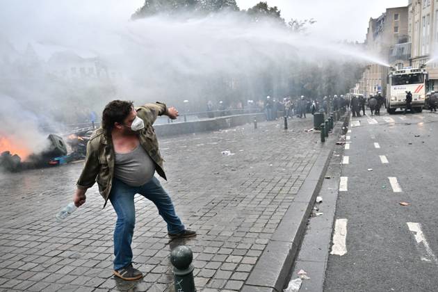 A protestor launches a bottle to the police during a national manifestation against the Federal Government s budgetary measures, under the Keep your hands out of our pockets! (Blijf uit onze zakken! - Pas dans nos poches) moniker, organised by the trade unions on Friday 9 October 2026 in Brussels.  DIRKxWAEM 189244546