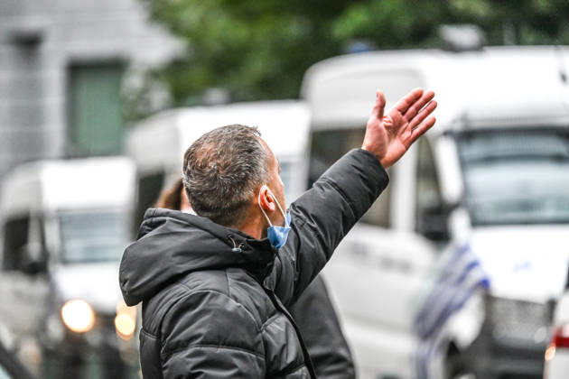 Middle-aged men engage in a heated confrontation with riot police during violent protests and a trade union demonstration near Rue du MarchÃ aux Herbes in central Brussels, Belgium, on 9 October 2026. The men argue with heavily equipped police officers amid tensions and unrest in the streets.