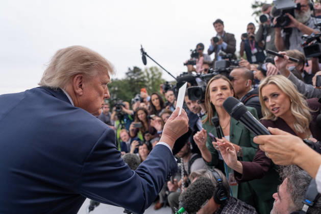 President Donald Trump is handed a note by White House Correspondent Association President Jacqui Heinrich as he speaks to members of the media on the South Lawn of the White House before boarding Marine One in Washington, DC on Friday, Oct. 9, 2026. Trump is heading to Syracuse on Friday to boost Republican gubernatorial candidate Bruce Blakeman, who is trailing Governor Kathy Hochul in polls ahead of November s election.  WASP20261009144 AaronxSchwartz