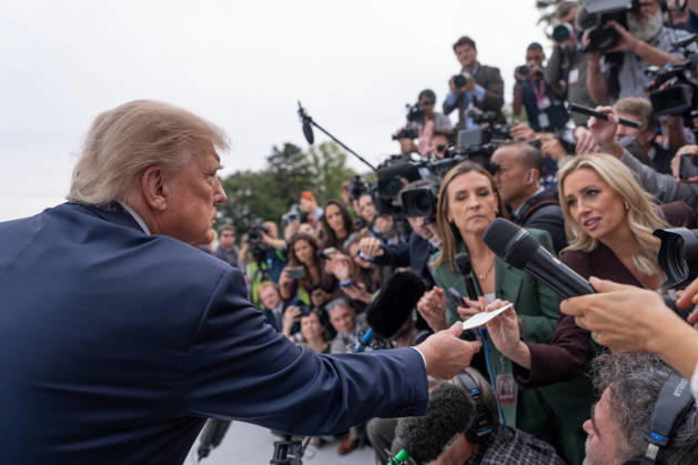 President Donald Trump is handed a note by White House Correspondent Association President Jacqui Heinrich as he speaks to members of the media on the South Lawn of the White House before boarding Marine One in Washington, DC on Friday, Oct. 9, 2026. Trump is heading to Syracuse on Friday to boost Republican gubernatorial candidate Bruce Blakeman, who is trailing Governor Kathy Hochul in polls ahead of November s election.  WASP20261009145 AaronxSchwartz