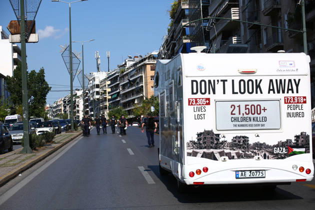 October 10, 2026, Athens, Attica, GREECE: A camper van displaying messages about casualties in Gaza travels along the route of a pro-Palestinian march as riot policemen walk ahead. Athens GREECE  - ZUMAx103 20261010_zip_x103_016 Copyright: xHarrisxXanthopoulosx