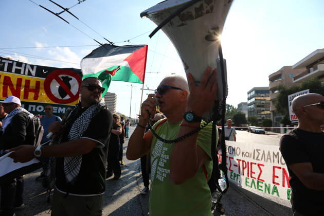 October 10, 2026, Athens, Attica, GREECE: A protester speaks into a megaphone as Palestinian flags and anti-war banners are displayed behind him. Athens GREECE - ZUMAx103 20261010_zip_x103_027 Copyright: xHarrisxXanthopoulosx