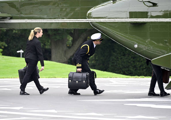 DC: Trump Departs for Clarksville, TN Aides carrying the briefcases referred to as the football board Marine One to accompany United States President Donald J Trump as he departs the South Lawn of the White House in Washington, DC, USA, en route Clarksville, Tennessee on Saturday, October 10, 2026. The President will participate in a campaign rally for Tennessee Republican candidates on the ballot in November. Credit: Ron Sachs Pool via CNP Washington District of Columbia United States  Copyright: xPool ABACAx
