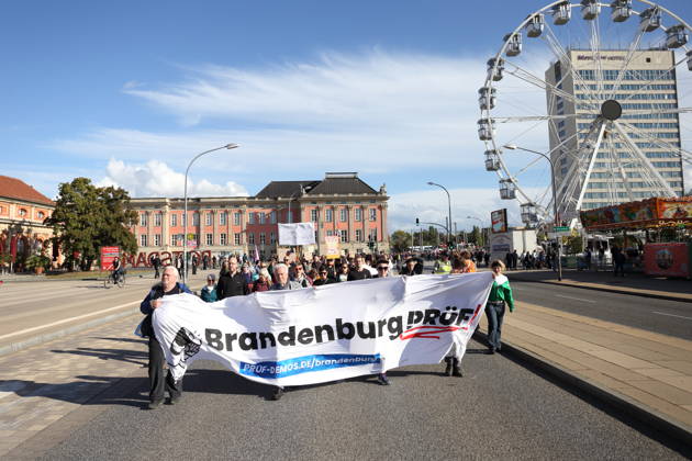 Demonstranten laufen mit Banner Brandenburg Prüf! auf der Breiten Straße während einer Demonstration für die Überprüfung rechtsextremer Parteien durch das Bundesverfassungsgericht, Potsdam, 10. Oktober 2026. Prüf-Demo in Potsdam