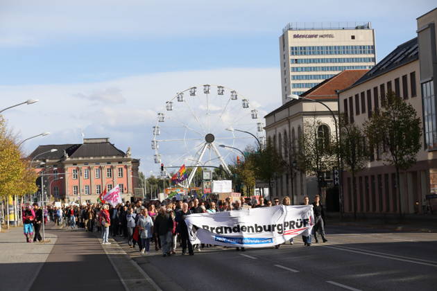 Demonstranten laufen mit Banner Brandenburg Prüf! auf der Breiten Straße während einer Demonstration für die Überprüfung rechtsextremer Parteien durch das Bundesverfassungsgericht, Potsdam, 10. Oktober 2026. Prüf-Demo in Potsdam