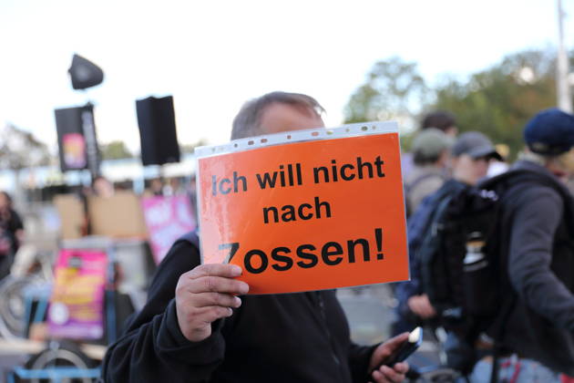 Ein Demonstrant läuft mit Schild Ich will nicht nach Zossen! auf der Langen Brücke während einer Demonstration gegen Wohnungsnot und steigende Mieten, Potsdam, 10. Oktober 2026. Mieten-Demo in Potsdam