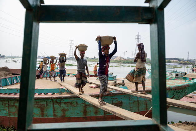 Migrant Workers Unload Sand Workers unload sand at a riverside site in Gabtoli, Dhaka, Bangladesh, on October 11, 2026. Many have left rural communities in search of employment in the capital, where daily labor provides a source of income but often involves strenuous work and limited financial security. Dhaka Bangladesh  Copyright: xBipulxAhmedx originalFilename: mondol-notitle261011_npZmT.jpg