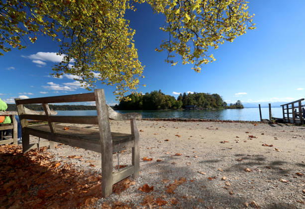 Ein Herbsttag in Feldafing, Feldafinger Park (Landkreis Starnberg). Hier der Blick auf den Starnberger See mit der Roseninsel, im Vordergrund eine Parkbank, Sitzbank und gefärbte Bäume, Laubfärbung, Laubbaum, herbstlich, Farbenspiel, Herbstlaub, Herbstfärbung, Blattfärbung, rot, gelb, gelbes Laub, Naturschauspiel, Herbstbild, Herbstimpression, Wetterbild ,goldener Oktober