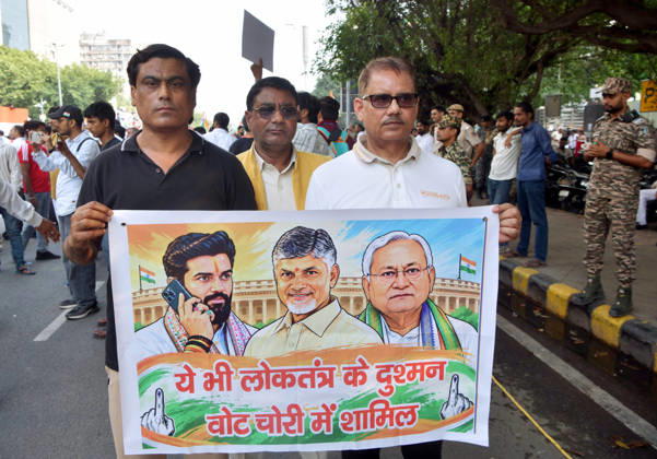 RECORD DATE NOT STATED INDIA Bloc protest march towards the Supreme Court in New Delhi New Delhi, Oct 12 (ANI): Three protesters hold a poster in their hands during the INDIA Bloc protest march towards the Supreme Court, in New Delhi on Monday. NEW DELHI Delhi India Copyright: xx ANI_20261012383