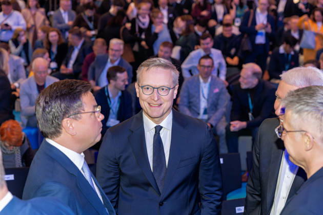 Berlin, 13.10.2026: Bundesdigitalminister Karsten Wildberger (Mitte) im Gespräch mit dem portugiesischen Minister Goncalo Saraiva Matias (links) und weiteren Gästen vor den voll besetzten Zuschauerreihen im Kongressbereich der Smart Country Convention in der Halle hub27. Portugal ist Partnerland der Smart Country Convention 2026 und präsentiert dort seine Erfahrungen mit der Digitalisierung der öffentlichen Verwaltung. Karsten Wildberger ist seit Mai 2025 Bundesminister für Digitales und Staatsmodernisierung und leitet das damals neu geschaffene Ministerium, das die Digitalisierung von Staat und Verwaltung bündeln soll; zuvor war der Manager Vorstandschef des Elektronikhändlers Ceconomy (MediaMarkt und Saturn). Die Smart Country Con