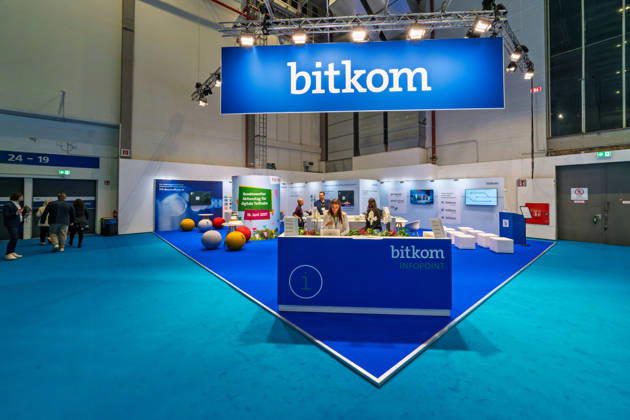 Berlin, 13.10.2026: Der Infopoint des Digitalverbands Bitkom auf der Smart Country Convention, die der Verband gemeinsam mit der Messe Berlin veranstaltet; ein Plakat am Stand wirbt für einen bundesweiten Aktionstag für digitale Teilhabe am 18. Juni 2027. Bitkom vertritt rund 2.200 Unternehmen der Digitalwirtschaft in Deutschland. Die Smart Country Convention (SCCON) ist die Kongressmesse für die Digitalisierung des öffentlichen Sektors und wird vom Digitalverband Bitkom gemeinsam mit der Messe Berlin veranstaltet. Vom 13. bis 15. Oktober 2026 treffen sich auf dem Berliner Messegelände Vertreter aus Bund, Ländern und Kommunen mit Unternehmen der Digitalwirtschaft, um über digitale Verwaltung, Smart City und digitale Souveränität zu