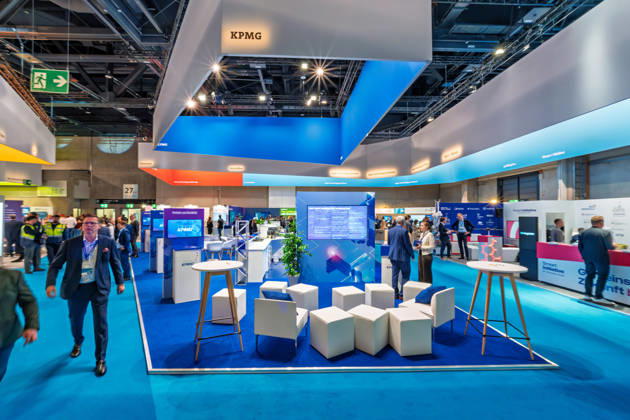 Berlin, 13.10.2026: Der Messestand der Wirtschaftsprüfungs- und Beratungsgesellschaft KPMG unter einem blau beleuchteten Deckenaufbau auf der Smart Country Convention in der Halle hub27. Beratungsunternehmen wie KPMG begleiten Bund, Länder und Kommunen bei der Digitalisierung ihrer Verwaltungsprozesse. Die Smart Country Convention (SCCON) ist die Kongressmesse für die Digitalisierung des öffentlichen Sektors und wird vom Digitalverband Bitkom gemeinsam mit der Messe Berlin veranstaltet. Vom 13. bis 15. Oktober 2026 treffen sich in der Halle hub27 Vertreter aus Bund, Ländern und Kommunen mit Unternehmen der Digitalwirtschaft, um über digitale Verwaltung, Smart City und digitale Souveränität zu diskutieren. KPMG-Stand auf der Smart Co