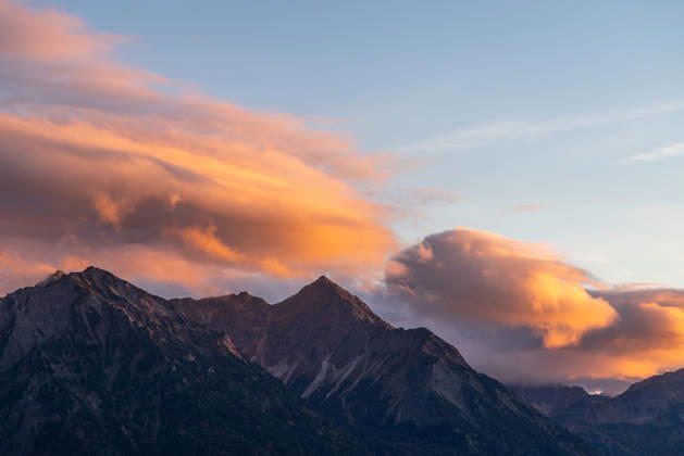 Herbstabend im Allgäu Die Wolken am Himmel leuchten im Licht der Abendsonne über den Gipfeln der Allgäuer Alpen., Bad Hindelang Bayern Deutschland