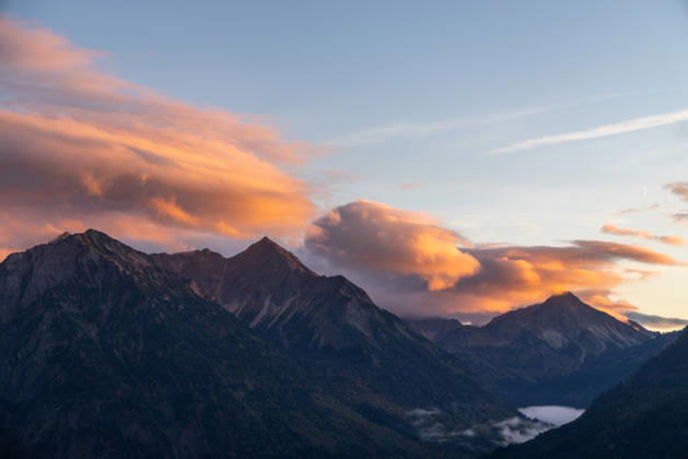 Herbstabend im Allgäu Die Wolken am Himmel leuchten im Licht der Abendsonne über den Gipfeln der Allgäuer Alpen., Bad Hindelang Bayern Deutschland