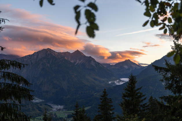 Herbstabend im Allgäu Die Wolken am Himmel leuchten im Licht der Abendsonne über den Gipfeln der Allgäuer Alpen., Bad Hindelang Bayern Deutschland
