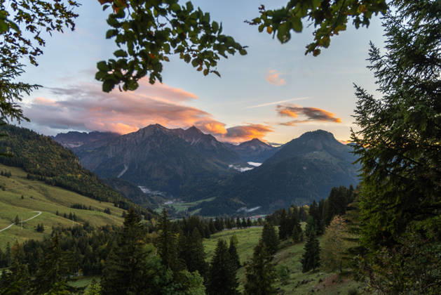 Herbstabend im Allgäu Die Wolken am Himmel leuchten im Licht der Abendsonne über den Gipfeln der Allgäuer Alpen., Bad Hindelang Bayern Deutschland
