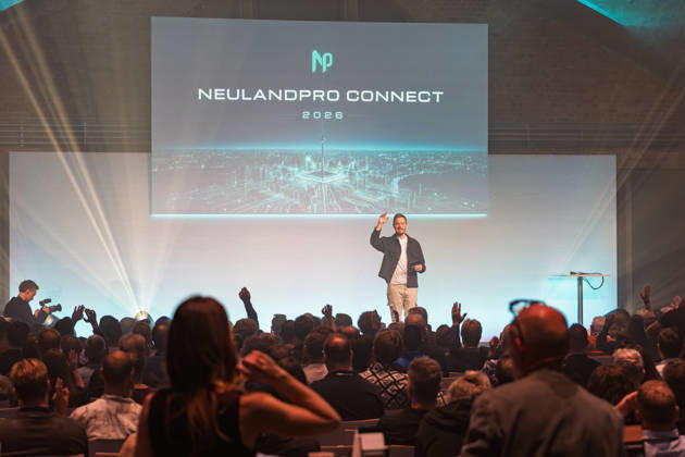 Berlin, 16.10.2026: Blick über das Publikum auf die Bühne der NeulandPro Connect 2026: Moderator Sascha Müller unter der Leinwand mit dem Schriftzug NeulandPro Connect 2026 fragt per Handzeichen ab, zahlreiche Besucherinnen und Besucher heben die Hand. Die zweitägige KI-Konferenz NeulandPro Connect 2026 findet am 16. und 17. Oktober im Westhafen Event & Convention Center (WECC) in Moabit statt, einem historischen Speichergebäude am Berliner Westhafen. Mit mehr als 50 Speakern sowie über 30 Workshops, Masterclasses und einem Hackathon richtet sich die Veranstaltung an Gründer, Führungskräfte, Unternehmen und KI-Interessierte. NeulandPro Connect 2026 - KI-Konferenz in Berlin