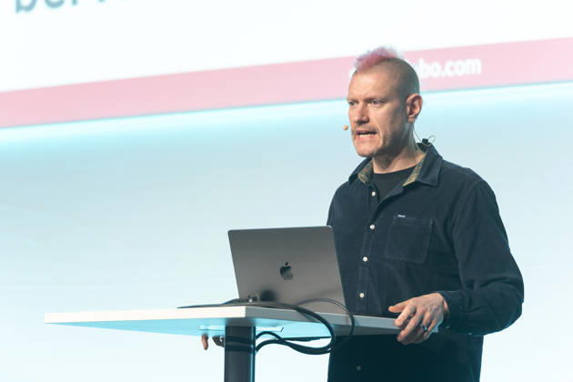 Berlin, 16.10.2026: Auf der NeulandPro Connect 2026 spricht der Publizist und Digital-Vordenker Sascha Lobo am Rednerpult, hinter ihm die Leinwand mit seiner Webadresse saschalobo.com. Die zweitägige KI-Konferenz NeulandPro Connect 2026 findet am 16. und 17. Oktober im Westhafen Event & Convention Center (WECC) in Moabit statt, einem historischen Speichergebäude am Berliner Westhafen. Veranstalter ist NeulandPro, eine Bildungs- und Medienmarke rund um Künstliche Intelligenz. Mit Vorträgen, Workshops und Hackathons richtet sich die Konferenz vor allem an kleine und mittelständische Unternehmen, Gründer und Führungskräfte, die KI praktisch einsetzen wollen; erwartet werden bis zu 1.000 Gäste. NeulandPro Connect 2026 - KI-Konferenz in
