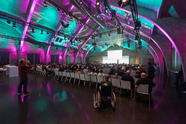 Berlin, 16.10.2026: Blick in die violett und türkis beleuchtete Halle des WECC während des Vortrags des Publizisten und Digital-Vordenkers Sascha Lobo auf der NeulandPro Connect 2026. Die zweitägige KI-Konferenz NeulandPro Connect 2026 findet am 16. und 17. Oktober im Westhafen Event & Convention Center (WECC) in Moabit statt, einem historischen Speichergebäude am Berliner Westhafen. Veranstalter ist NeulandPro, eine Bildungs- und Medienmarke rund um Künstliche Intelligenz. Mit Vorträgen, Workshops und Hackathons richtet sich die Konferenz vor allem an kleine und mittelständische Unternehmen, Gründer und Führungskräfte, die KI praktisch einsetzen wollen; erwartet werden bis zu 1.000 Gäste. NeulandPro Connect 2026 - KI-Konferenz i