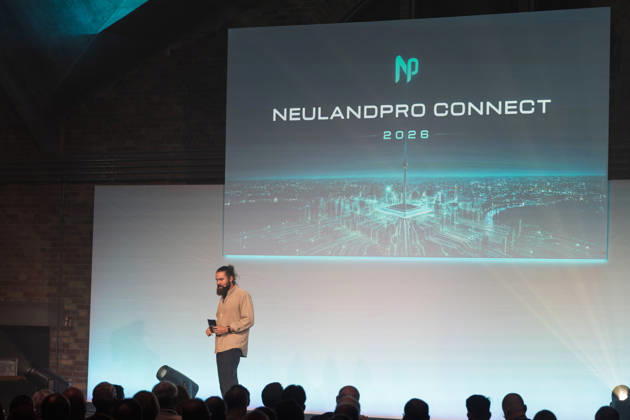 Berlin, 16.10.2026: Julius Herzberg (Veranstalter) spricht bei der NeulandPro Connect. Die zweitägige KI-Konferenz NeulandPro Connect 2026 findet am 16. und 17. Oktober im Westhafen Event & Convention Center (WECC) in Moabit statt, einem historischen Speichergebäude am Berliner Westhafen. Veranstalter ist NeulandPro, eine Bildungs- und Medienmarke rund um Künstliche Intelligenz. Mit Vorträgen, Workshops und Hackathons richtet sich die Konferenz vor allem an kleine und mittelständische Unternehmen, Gründer und Führungskräfte, die KI praktisch einsetzen wollen; erwartet werden bis zu 1.000 Gäste. NeulandPro Connect 2026 - KI-Konferenz in Berlin