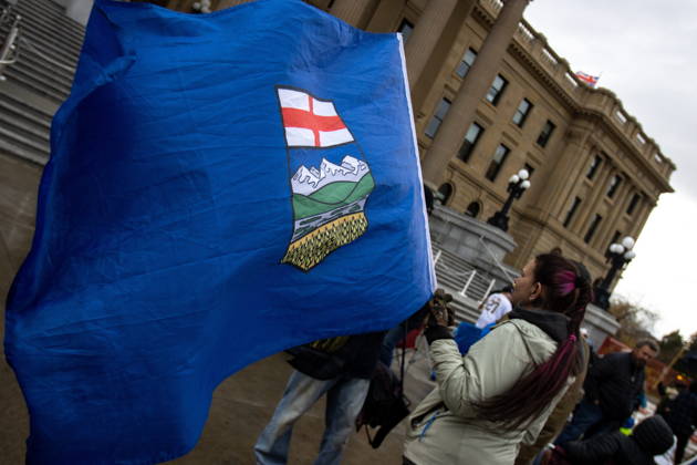 October 17, 2026, Edmonton, Ab, Canada: An attendee holds an Alberta flag during an Alberta independence rally at the Alberta legislature, in Edmonton on Saturday, Oct. 17, 2026. Edmonton Canada  - ZUMAc35_ 20261017_zaf_c35_042 Copyright: xAmandaxMayxEricksonx