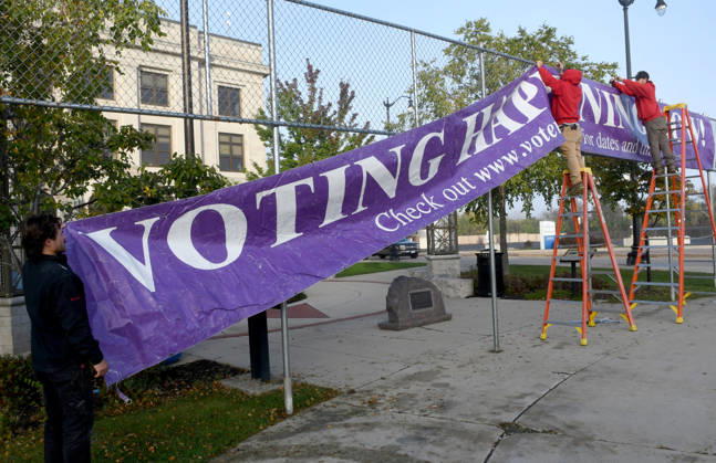 October 20, 2026, Racine, Wisconsin, USA: Workers put up a large banner announcing the start of voting as voters come to Racine City Hall Tuesday morning October 20, 2026 on the first day of early voting in Wisconsin for the midterm elections. There are two closely watched Congressional races, including the First District which includes Racine, and a contentious gubernatorial race on the ballot. Racine USA  - ZUMAh154 20261020_znp_h154_004 Copyright: xMarkxHertzbergx