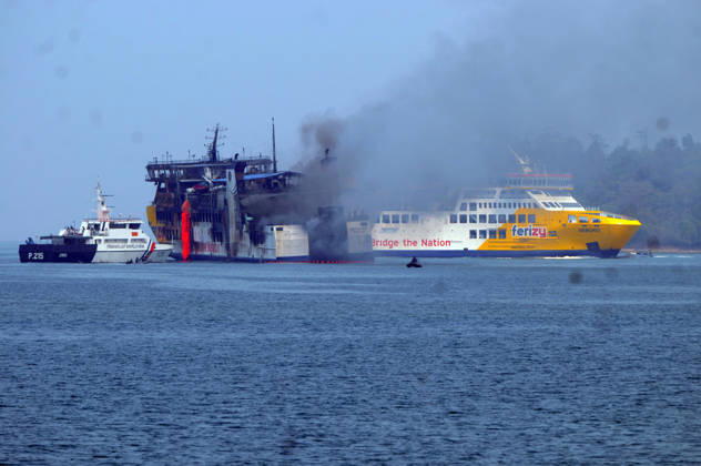 Efforts are underway to extinguish a fire that broke out on a passenger ferry in Indonesia s Cilegon PELABUHAN MERAK, CILEGON, INDONESIA - OCTOBER 21: Fireboats take turns spraying water onto the passenger ferry KMP Batumandi to cool down the vessel after it caught fire while preparing to dock off Merak Port in Cilegon, Banten, Indonesia on Wednesday, October 21, 2026. The vessel caught fire on Tuesday, October 20, and rescue operations remain underway as the ship continues to emit smoke. Water is continuously sprayed to cool the vehicle deck containing numerous cars, motorcycles, buses, and trucks, while authorities confirm no fatalities have been reported. Dasril Roszandi Anadolu Pelabuhan Merak Indonesia. Editorial use only. Please get  Copyright: x2026xAnadoluxDasrilxRoszandix