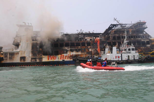 Efforts are underway to extinguish a fire that broke out on a passenger ferry in Indonesia s Cilegon PELABUHAN MERAK, CILEGON, INDONESIA - OCTOBER 21: Fireboats take turns spraying water onto the passenger ferry KMP Batumandi to cool down the vessel after it caught fire while preparing to dock off Merak Port in Cilegon, Banten, Indonesia on Wednesday, October 21, 2026. The vessel caught fire on Tuesday, October 20, and rescue operations remain underway as the ship continues to emit smoke. Water is continuously sprayed to cool the vehicle deck containing numerous cars, motorcycles, buses, and trucks, while authorities confirm no fatalities have been reported. Dasril Roszandi Anadolu Pelabuhan Merak Indonesia. Editorial use only. Please get  Copyright: x2026xAnadoluxDasrilxRoszandix