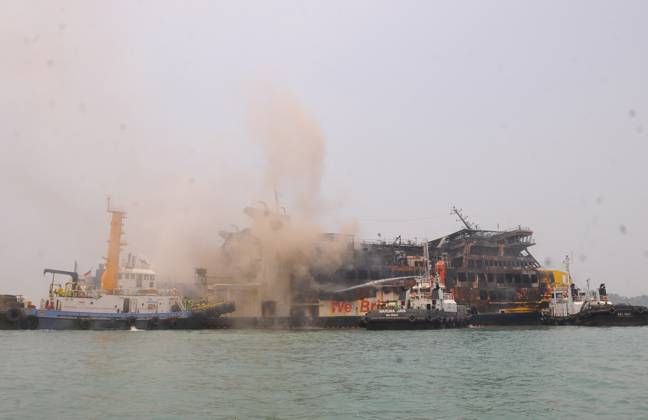 Efforts are underway to extinguish a fire that broke out on a passenger ferry in Indonesia s Cilegon PELABUHAN MERAK, CILEGON, INDONESIA - OCTOBER 21: Fireboats take turns spraying water onto the passenger ferry KMP Batumandi to cool down the vessel after it caught fire while preparing to dock off Merak Port in Cilegon, Banten, Indonesia on Wednesday, October 21, 2026. The vessel caught fire on Tuesday, October 20, and rescue operations remain underway as the ship continues to emit smoke. Water is continuously sprayed to cool the vehicle deck containing numerous cars, motorcycles, buses, and trucks, while authorities confirm no fatalities have been reported. Dasril Roszandi Anadolu Pelabuhan Merak Indonesia. Editorial use only. Please get  Copyright: x2026xAnadoluxDasrilxRoszandix