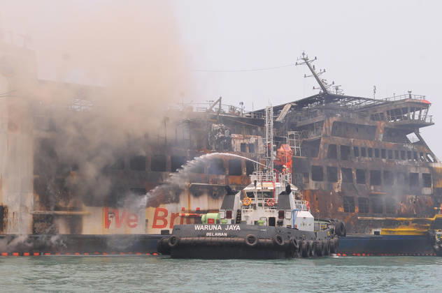 Efforts are underway to extinguish a fire that broke out on a passenger ferry in Indonesia s Cilegon PELABUHAN MERAK, CILEGON, INDONESIA - OCTOBER 21: Fireboats take turns spraying water onto the passenger ferry KMP Batumandi to cool down the vessel after it caught fire while preparing to dock off Merak Port in Cilegon, Banten, Indonesia on Wednesday, October 21, 2026. The vessel caught fire on Tuesday, October 20, and rescue operations remain underway as the ship continues to emit smoke. Water is continuously sprayed to cool the vehicle deck containing numerous cars, motorcycles, buses, and trucks, while authorities confirm no fatalities have been reported. Dasril Roszandi Anadolu Pelabuhan Merak Indonesia. Editorial use only. Please get  Copyright: x2026xAnadoluxDasrilxRoszandix