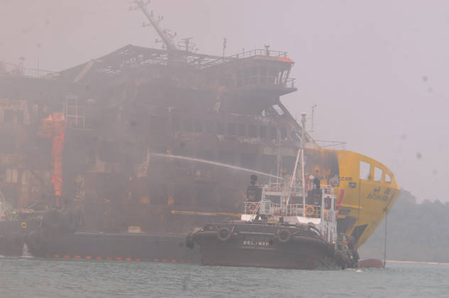 Efforts are underway to extinguish a fire that broke out on a passenger ferry in Indonesia s Cilegon PELABUHAN MERAK, CILEGON, INDONESIA - OCTOBER 21: Fireboats take turns spraying water onto the passenger ferry KMP Batumandi to cool down the vessel after it caught fire while preparing to dock off Merak Port in Cilegon, Banten, Indonesia on Wednesday, October 21, 2026. The vessel caught fire on Tuesday, October 20, and rescue operations remain underway as the ship continues to emit smoke. Water is continuously sprayed to cool the vehicle deck containing numerous cars, motorcycles, buses, and trucks, while authorities confirm no fatalities have been reported. Dasril Roszandi Anadolu Pelabuhan Merak Indonesia. Editorial use only. Please get  Copyright: x2026xAnadoluxDasrilxRoszandix