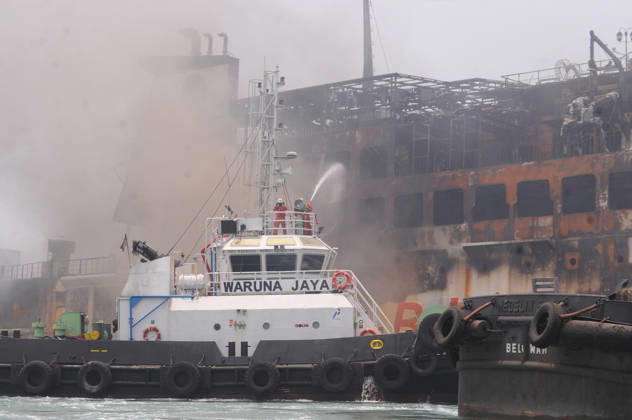 Efforts are underway to extinguish a fire that broke out on a passenger ferry in Indonesia s Cilegon PELABUHAN MERAK, CILEGON, INDONESIA - OCTOBER 21: Fireboats take turns spraying water onto the passenger ferry KMP Batumandi to cool down the vessel after it caught fire while preparing to dock off Merak Port in Cilegon, Banten, Indonesia on Wednesday, October 21, 2026. The vessel caught fire on Tuesday, October 20, and rescue operations remain underway as the ship continues to emit smoke. Water is continuously sprayed to cool the vehicle deck containing numerous cars, motorcycles, buses, and trucks, while authorities confirm no fatalities have been reported. Dasril Roszandi Anadolu Pelabuhan Merak Indonesia. Editorial use only. Please get  Copyright: x2026xAnadoluxDasrilxRoszandix