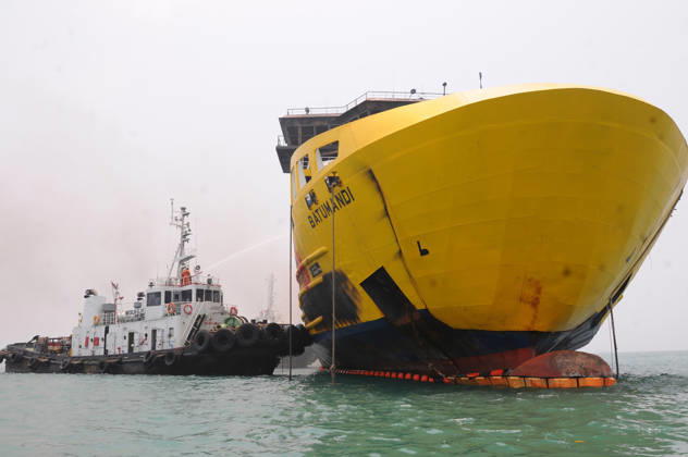 Efforts are underway to extinguish a fire that broke out on a passenger ferry in Indonesia s Cilegon PELABUHAN MERAK, CILEGON, INDONESIA - OCTOBER 21: Fireboats take turns spraying water onto the passenger ferry KMP Batumandi to cool down the vessel after it caught fire while preparing to dock off Merak Port in Cilegon, Banten, Indonesia on Wednesday, October 21, 2026. The vessel caught fire on Tuesday, October 20, and rescue operations remain underway as the ship continues to emit smoke. Water is continuously sprayed to cool the vehicle deck containing numerous cars, motorcycles, buses, and trucks, while authorities confirm no fatalities have been reported. Dasril Roszandi Anadolu Pelabuhan Merak Indonesia. Editorial use only. Please get  Copyright: x2026xAnadoluxDasrilxRoszandix