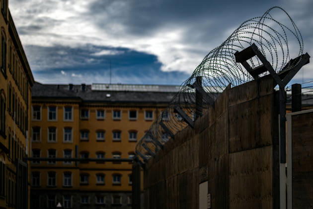 21.10.2026, Deutschland,Sachsen, Bautzen : Eine Überwachungskamera und eine Straßenlaterne vor den historischen Gebäuden der Justizvollzugsanstalt Bautzen in Sachsen. Die Gefängnisanlage ist durch Mauern und Sicherheitszäune gesichert.