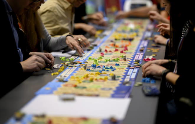 Besucher und Besucherinnen Spielen die Siedler von Catan (Kosmos) an einem langen Tisch, Spieltisch, am 22.10.2026 Messe SPIEL Essen vom 22.10 - 25.10.2026 in E s s e n Deutschland. Grugahalle