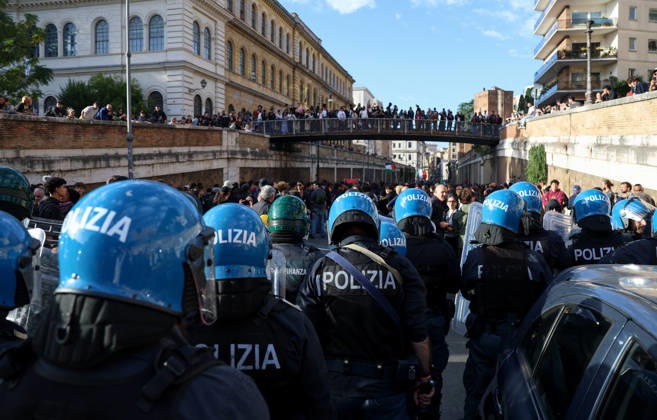 (261024) -- ROME, Oct. 24, 2026 -- Police block the demonstrators from marching towards the Colosseum during an anti-war march in Rome, Italy, Oct. 24, 2026. Protests over rising living costs, military expansion and increased arms spending swept across several Italian cities on Saturday, with clashes between demonstrators and police reported in multiple locations. In Rome, demonstrators set off from Piazza della Repubblica, according to the ANSA news agency. Clashes erupted between protesters and police in the city center later in the evening, prompting police to use water cannons and tear gas in an attempt to disperse the crowds. ) ITALY-ROME-PROTESTS WangxKaiyan