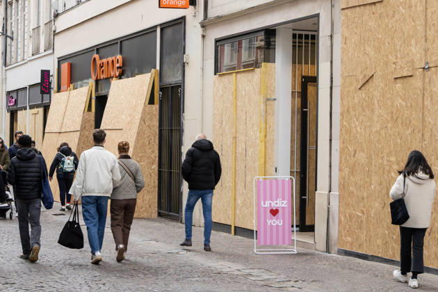 (261024) -- LILLE, Oct. 24, 2026 -- People walk past boarded-up shops in Lille, France, Oct. 24, 2026. Around 410,000 people took part in a new round of protests across France on Saturday, French news channel BFM TV reported, citing the Interior Ministry. (Photo by Xinhua) FRANCE-LILLE-PROTEST SebastienxCourdji 