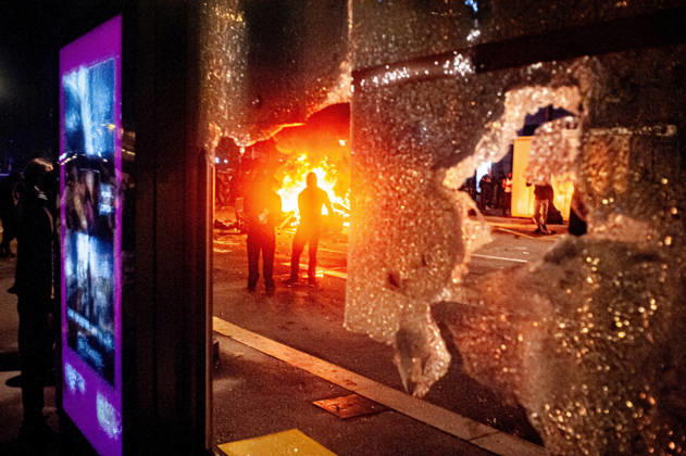 October 24, 2026, Barcelona, Spain: A burning barricade is seen through the shattered glass of a bus shelter amid unrest in central Barcelona. Clashes between demonstrators and police, looting and widespread vandalism were reported across the city centre overnight. Barcelona Spain - ZUMAb137 20261024_fap_b137_012 Copyright: xJordixBoixareux
